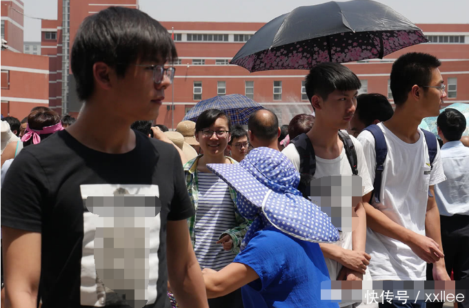 家长围成大圈等待考生 为第一个出考场的男孩