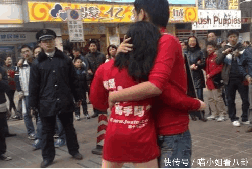 一对男女在街头紧紧相拥不分开 , 路人看到男子身上的字后“哭笑